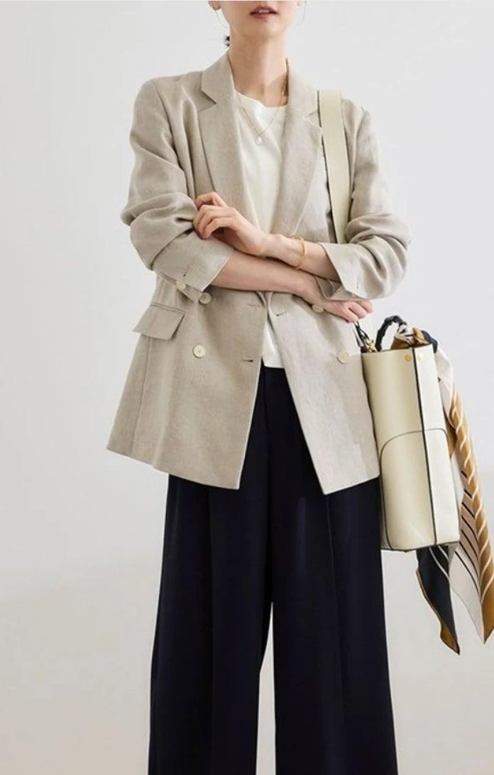 ベージュのリネンジャケット × 黒パンツ。天然素材の洗練